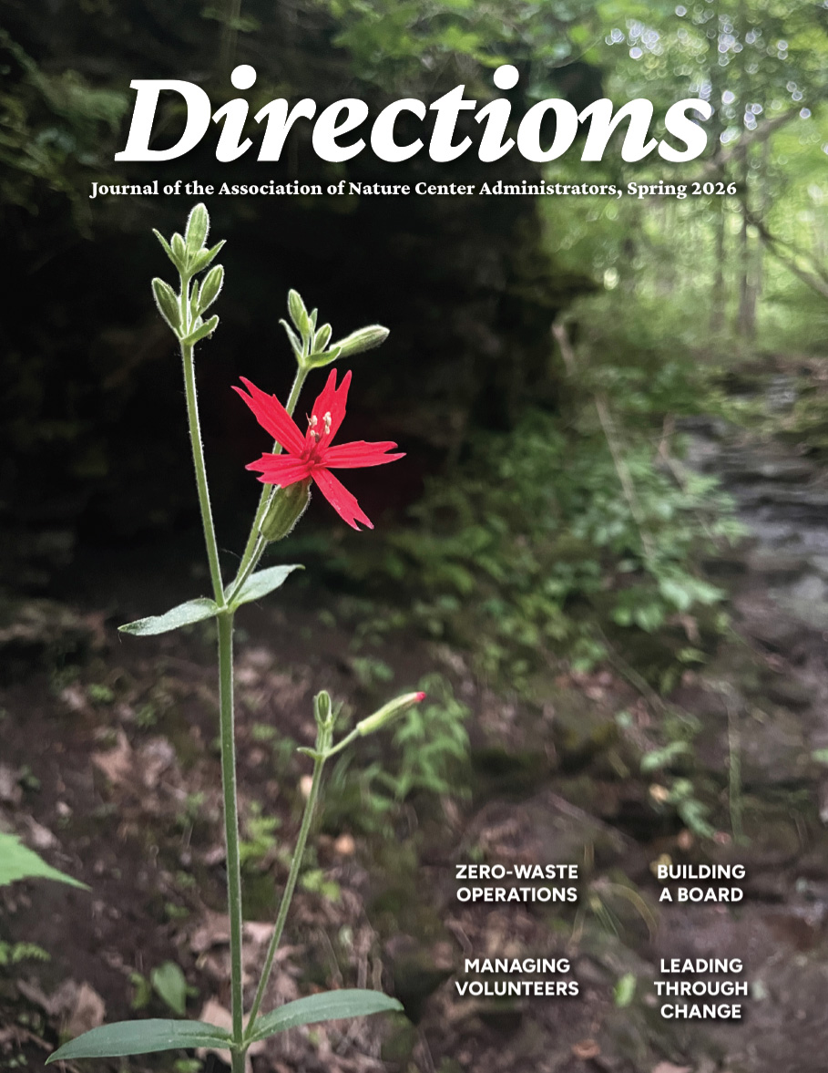 A magazine cover featuring a five-pointed bright red flower standing alone in a forest. At the top, "Directions" in large font.