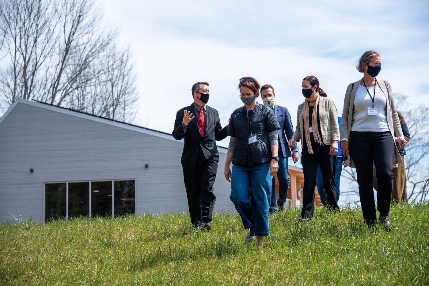 Drew Dumsch (far left) gives a tour during the ribbon cutting ceremony for River Bend Farm on April 24, 2021