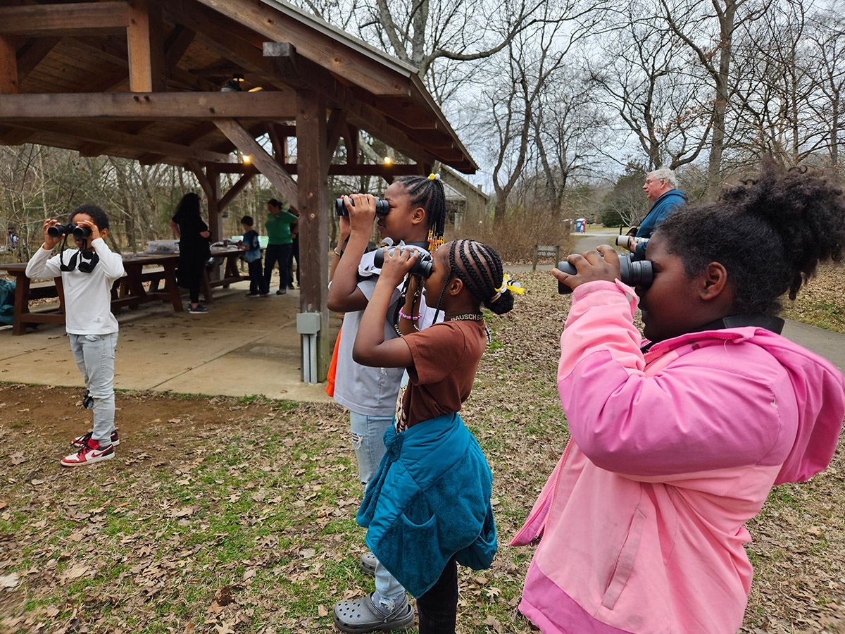 web Kids using binoculars to look at birds during a winter bird banding public program - Rachel Anderson copy
